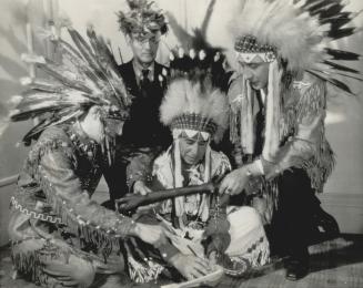 Six nations Indians from the Brantford and Caughnawaga reservations are shown in pow-wow in a San Francisco hotel room
