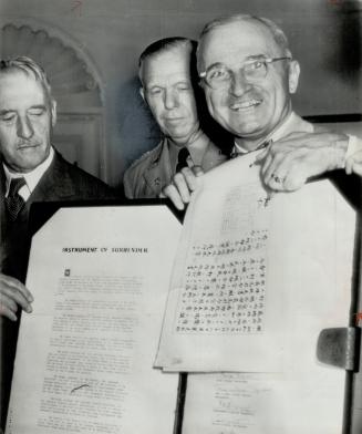 Hirohito signed here, President Truman says happily as he points to the emperor's signature on the surrender proclamation. Beneath is the official ins(...)