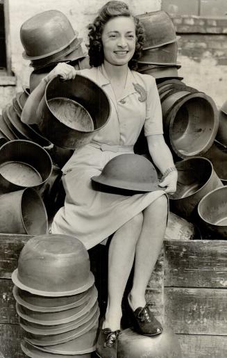 Helmets, 4,000,000 Of Them Like The One Held By Alice Rogers, were turned out by General Steel Wares Ltd