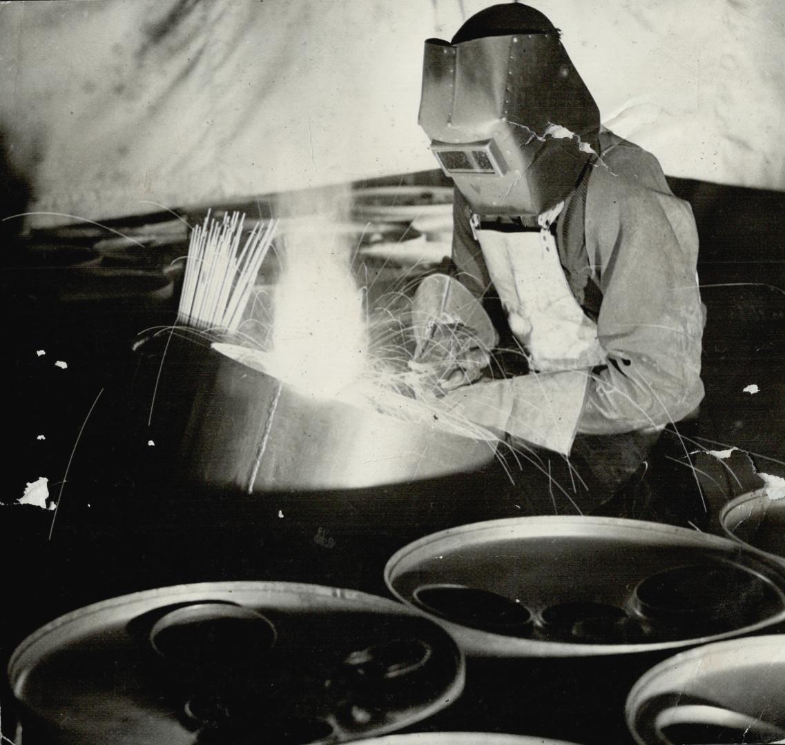 The Man in the Iron Mask is busy welding the ends of depth charge containers in place