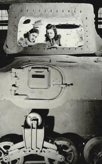 Two Young Women are here inspecting the equipment in a Ram tank before the gun shield is rivetted in place and the cannan installed. Designed by Maj. (...)
