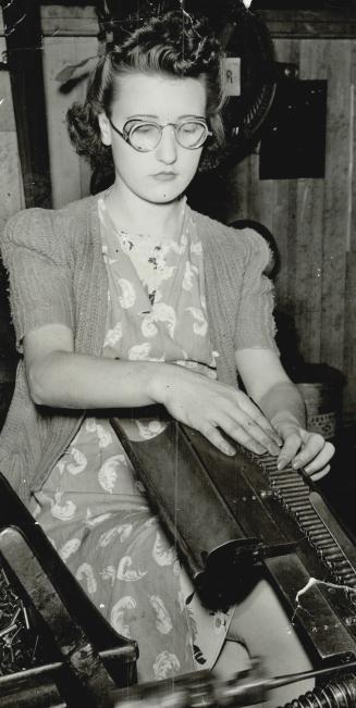 Putting order into the chaos of bullets brought to her by a travelling belt, this smiling miss, in the same Quebec plant, is as nonchalant as if she were only packing caramels