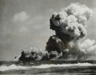 A blazing inferno from raging fires touched off by three torpedo hits from a Japanese submarine is the U