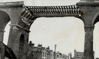 Hit-and-run raids are still carried out by Nazi planes over England and in a recent sneak attack, the Germans bombed out one archway in a Brighton rai(...)