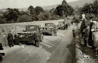 Flower-covered caskets of 28 English schoolboys and their woman headmaster are borne in motor trucks to a communal grave in an English village. They w(...)