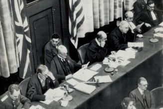International military tribunal members presiding are shown listening to the proceedings at the Nuremberg war crimes trial. They'are, left to right, s(...)