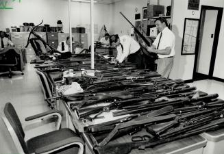 Apartment Arsenal, Metro police officers examine some of the 50 rifles, shotguns and handguns, along with ammunition and a crossbow, found in a one-be(...)