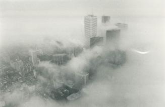 A gray day downtown, Dense fog obstructs the view of downtown Toronto skyline from the CN Tower yesterday
