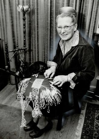 Delicate beauty: Phylis Attwell demonstrates pillow lace-making, twisting and plaiting threads together over a pillow base, with two antique bobbins from her collection