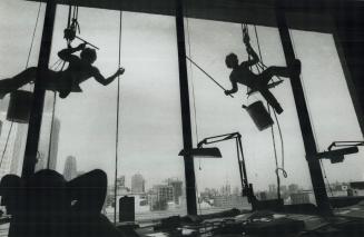 Changing skyline, Swinging high-above the ground on their precarious perches, window washer Dennis Brillian (right) and his partner are on the outline(...)