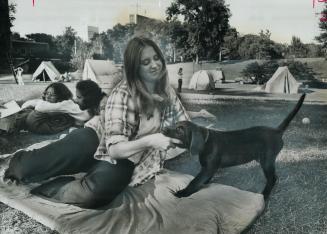 At Wacheea, the tent city for young travellers on the University of Toronto Campus, Beth Calengor, 18, of Birmingham, Mich., plays with her dog, Jump.(...)
