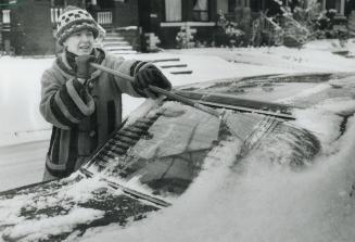 Dominique Gendron sweeps the season's first snowfall from her car on Palmerston Ave