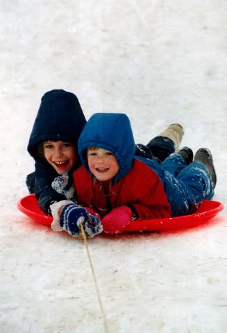 Cold day for an uphill battle, Kristy Lawrence, 3, right, and her cousin Aimee Huizinga, 8, enjoy sledding twice as much as the other kids in Milton b(...)