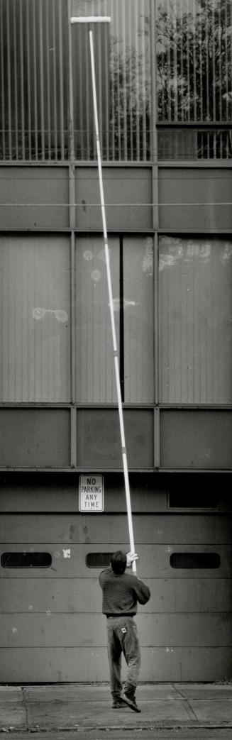Cleaning up, Window washer Frank Underwood reaches for the tough spots with his three-storey-high cleaning brush on a Yonge St. office building yesterday