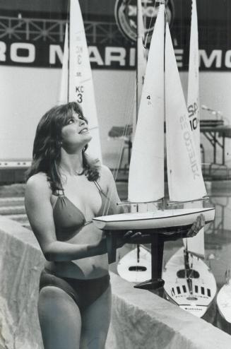 Setting Sails, Miss Boatshow '81, Brenda Hughes, 17, of Etobicoke, lines up radio-controlled model boats to start the model sailboat races yesterday at the International Boat Show in the Coliseum