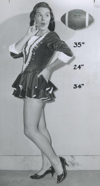 Miss Argonaut for 1958, Barbara Lorraine Bricker, 20, casts admiring glance at football