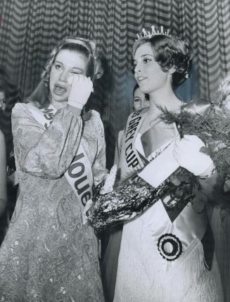 The tense moment of triumph, As the Miss Grey Cup crown is placed on the head of Barbara Casault, Miss Edmonton Eskimo, the nerves of Miss Montreal Al(...)