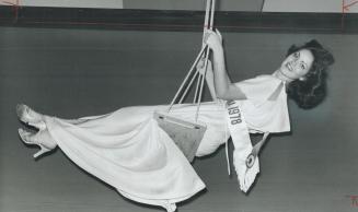 Swing into spring, Miss Toronto 1978, Carol McCartney, dangled from a swing strung from the ceiling at the Sheraton Centre as about 500 leaders of Met(...)