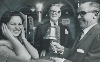 Linda Leslie, Miss United Appeal, holds ears as bell opens the campaign, In on the ringing ceremony are UA chairman Charles Brower (centre) and William Ingram