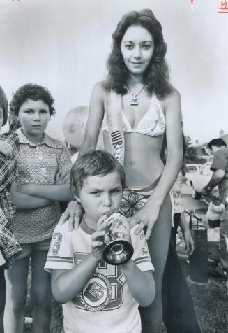 Hey! My sister won, Blowing a horn, 5-year-old Eric Althoff of Downsview precedes his sister Monica, 17, after she was chosen Miss Ourland Bikini duri(...)