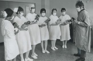 At mount Sinai hospital -- two sets of triplets, Star photographer Boris Spremo, wearing a gauze face mask, tries to sort out which nurse is holding w(...)