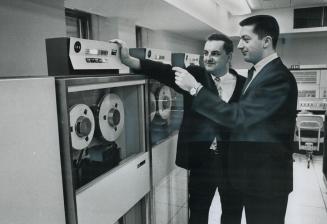 Blind computer programmer Gerry O'Bonsawin (right) discusses a computer program he is working on with operator Edward Evans at Workmen's Compensation (...)