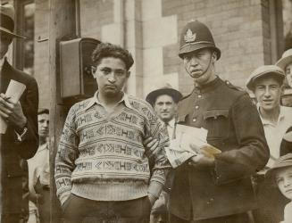 Arrested While Distributing Literature, Able Pearl Pearl and the police constable who arrested him to-day at Spadina Ave. and Queen St. while distributing communist literature