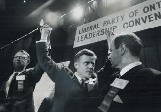 The victor, 39-year-old Andrew Thompson (centre), new leader of the Ontario Liberals who won the last ballot 772-540, holds up arms of Robert Nixon (l(...)