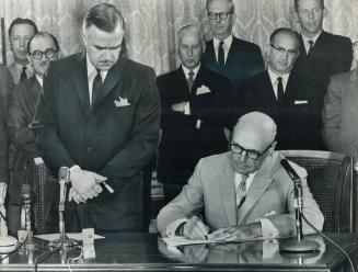 Setting Election Day, Premier John Robarts looks on as Lieutenant-Governor Earl Rowe signs the warrant calling for an Ontario election on Wednesday, Sept. 25