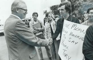 John Macbeth, Progressive Conservative candidate in York West riding, shakes hands with a protester outside his campaign headquarters on Dundas St. W.(...)