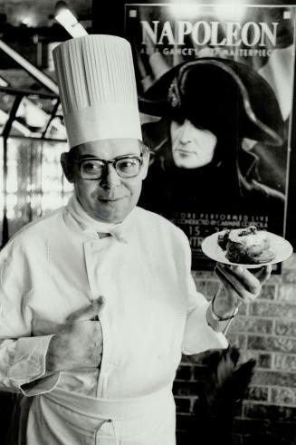 They're not banished: Daniel Dunas, Hazelton Lane executive chef, holds one of his specialities, Eggs Elba, backgrounded by a poster advertising the 1927 film epic, Napoleon