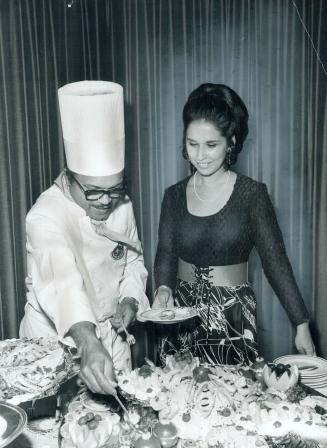 Gilberto Smith serves sea food to Mrs. Lillian Borgas, The Cuban chef brought tasty recipes to Toronto