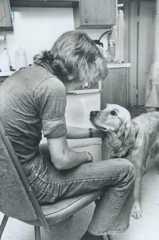 Troubled youth enjoys a quiet moment with a golden retriever in Metro group home
