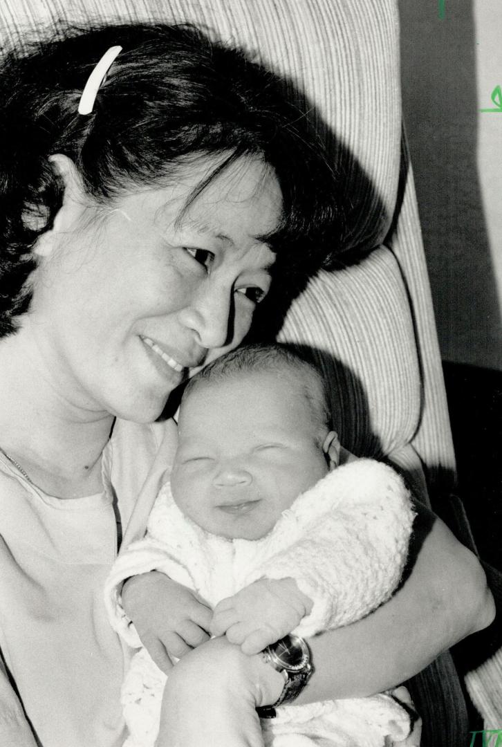 A Smile for Nurse, A newborn baby boy abandoned in a Brampton medical building yesterday smiles for nurse Grace Chiu as she cuddles him at peel Memori(...)