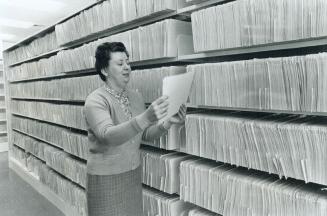Confidential files in the Ontario department of social and family services are examined by Betty Graham, director of child welfare for the department.(...)