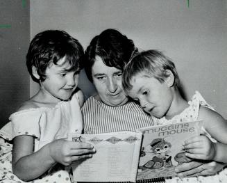 Perhaps for last time, Mrs. Arthur Timbrell reads bedtime story to the little sisters she wants to adoptéPeggy (left) and Valerie. Children's Aid Soci(...)