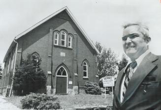 The Pastor, Rev. John Creighton, stands in front of Munn's United Church that is to be moved 50 feet back to allow widening of Highway 5. The original(...)