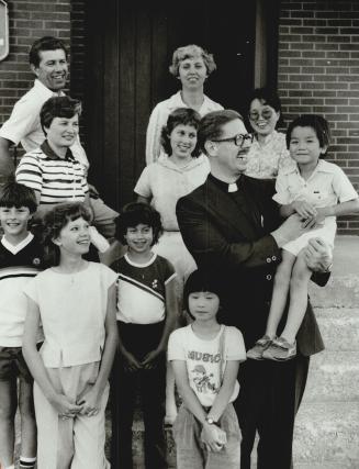 Lone Lutherans: Rev. John Drickamer gives 5-year-old Alfred Tsang a boost as he mingles with members of his congregation outside Immanuel Lutheran Chu(...)