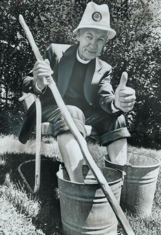 In pails of cool water, Rev. William C. Hewitt soaks his feet prior to 140-mile pilgrims' walk from Winchester to Canterbury to pay off balance of mor(...)
