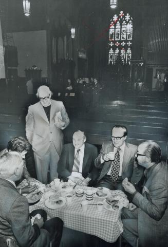 Desmond Hunt, minister of the Anglican Church of the Messiah on Avenue Road, talks to businessmen in Holy Trinity Church during the lunch hour yesterd(...)