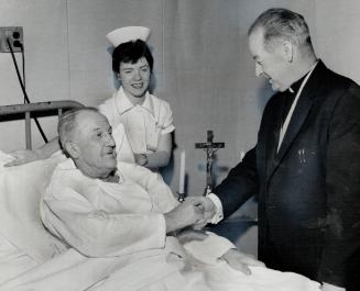Roman Catholic chaplain Rev. W. Mann visits reg noble, nurse Nancy Beatty looks as priest and former hockey great chat at Toronto general