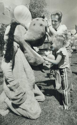 Rev. Jim Neale introduces Christine Brawley, 4, to Pluto (his son, Michael) during a crusade