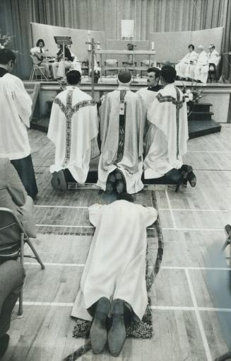 Prostrating himself in the traditional act of surrender and obedience to God and the Church, Rev