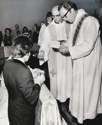 One of the first marrie dmen to be ordained deacons in Roman Catholic Church, William Sandford assists at the marriage of his daughter, Maureen, to Gi(...)