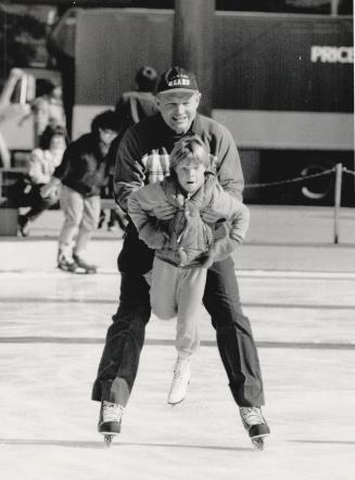 An ice time of the year. Father Bill Scanlon of St. John's church in Newmarket gives Martha Gorman, 7, a lift on the new ice at Nathan Phillips Square(...)