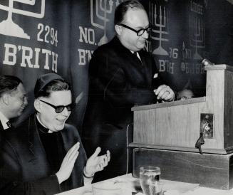 Blind Minister, Rev. Harry J. Sutcliffe of Brooklyn, seated, and Mayor Philip Givens, speaking, both talked in English and Hebrew at B'nai B'rith men'(...)