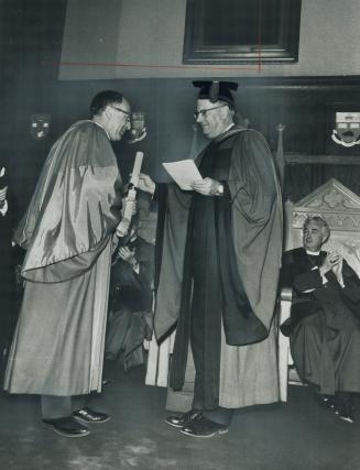 In ritual ceremony at Wycliffe College this week Principal Dr. Leslie Hunt, right, presents doctorate to Anglican Primate Ted Scott. Scott told gradua(...)