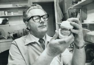 Denturist Egil Chramer examines a set of dentures