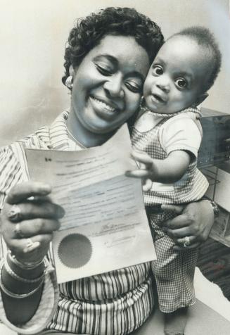 Happy mother Clevette German, 28, with her 13-month-old son Gregory shows the permit that allowed her to return to Canada only 15 minutes after she wa(...)