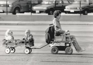 Happy hitch-hikers. Matt Van Geffen tows his daughter, Kari, 4 (at the back of the wagon), and her friend, Leslie Meyers, 3, home along Queen's Quay
